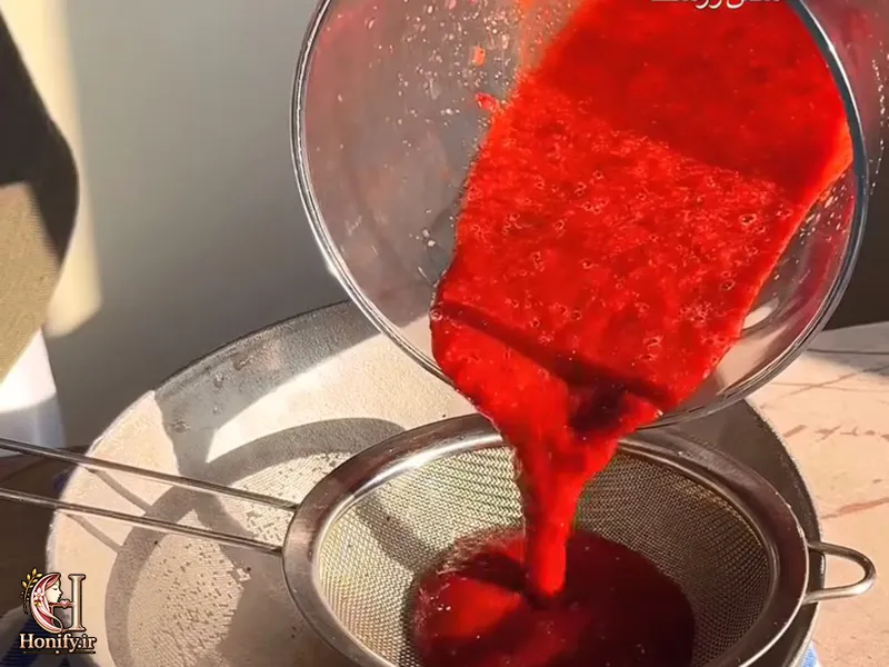 عبور عصاره زرشک از صافی برای جدا کردن تفاله